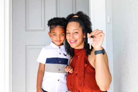 article image - Habitat Homeowner Amanda and her son at their home dedication, made possible through partnerships with Pelican Landing and The Colony